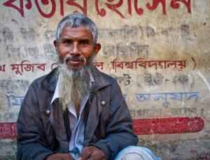Old man in front of a painted wall