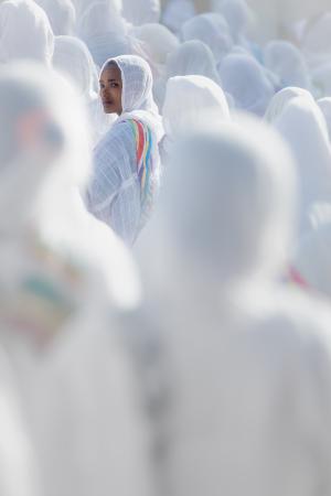 A woman facing the camera in a white crowd