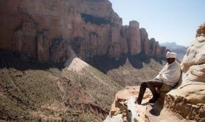 Priest at the top of a monolitich church