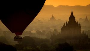 Hot-air balloon and pagoda at sunset